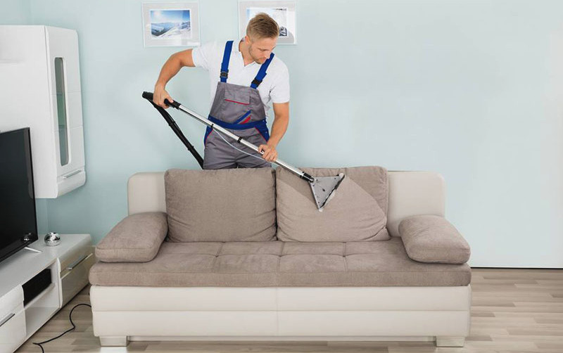 Concepto de limpieza de muebles. Limpiar el sofá con un limpiador